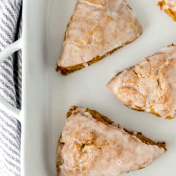pumpkin scones on a white platter with a napkin