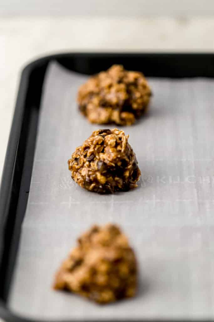unbaked tahini cookies on parchment-lined baking sheet.