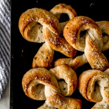 soft pretzels on baking sheet beside a cloth napkin