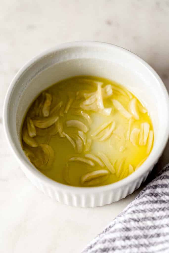 garlic oil for garlic green beans in small white bowl with napkin