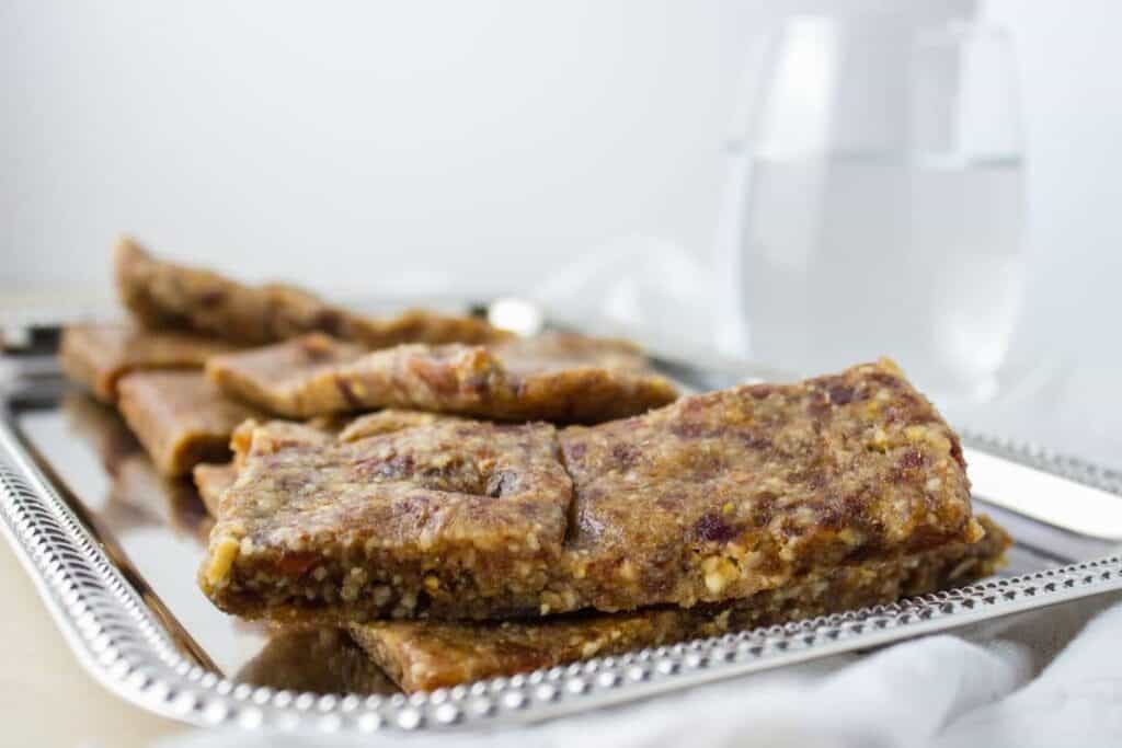 close up side view of bars on silver platter with glass of water in the background