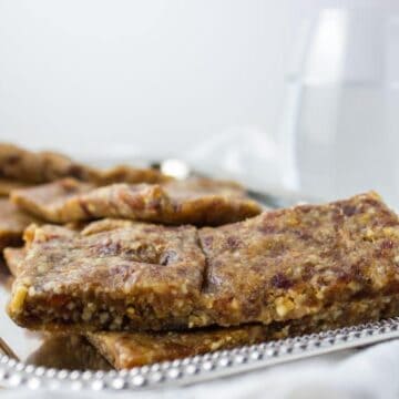 close up side view of bars on silver platter with glass of water in the background