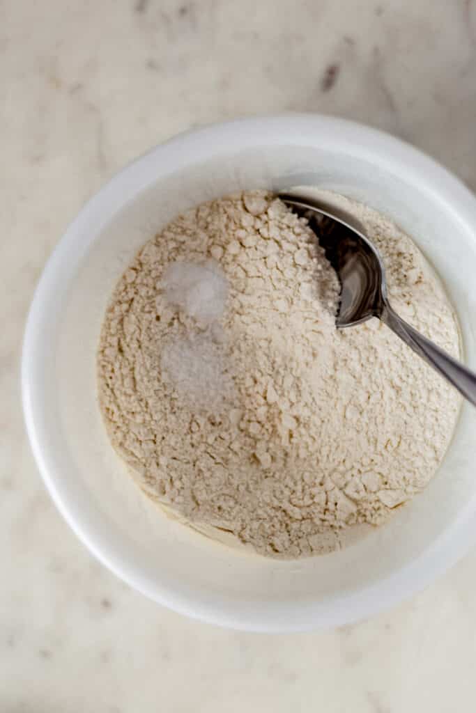 mixing bowl with flour, salt, baking soda, and a spoon