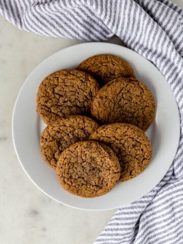 coffee cookies on a white plate next to a napkin