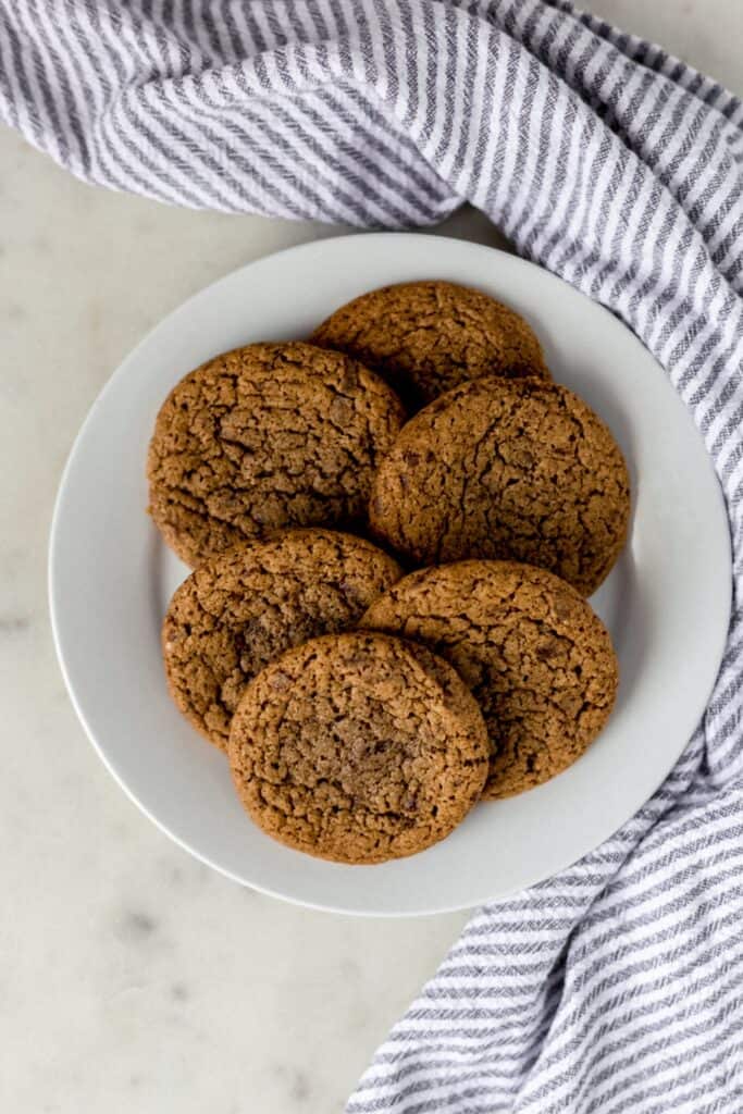 coffee cookies on a white plate next to a napkin