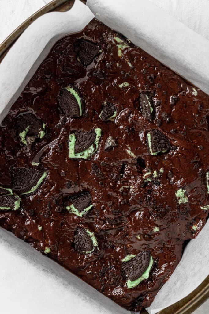 mixture to make mint brownies added to square baking pan lined with parchment paper.