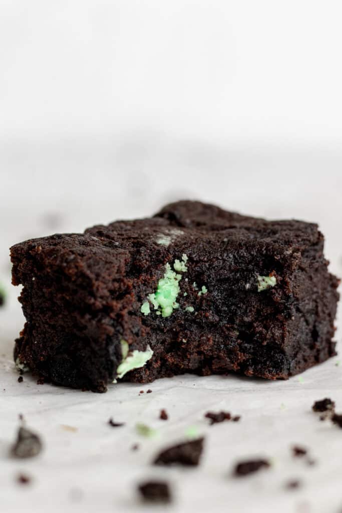 side view of single square cut brownie with a bite into it. 