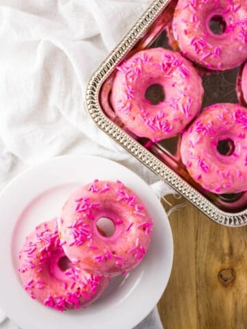 overhead view of doughnuts on silver platter and white plate