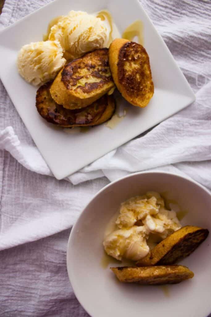 overhead view of french toast and ice cream on square white plate and white bowl 