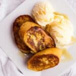 overhead view of finished french toast and ice cream on square white plate