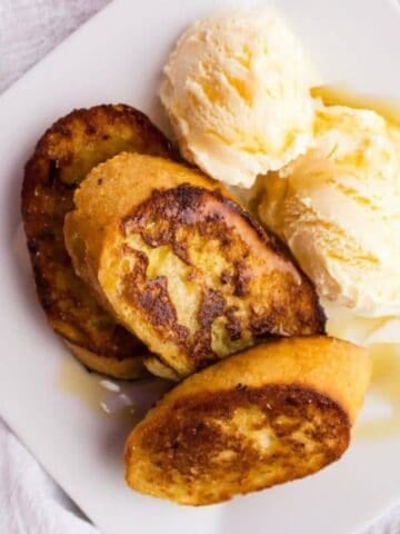 Overhead view of french toast and ice cream on plate.