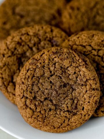 close up side view baked coffee cookies on white plate