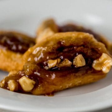 close up side view sticky buns on white plate