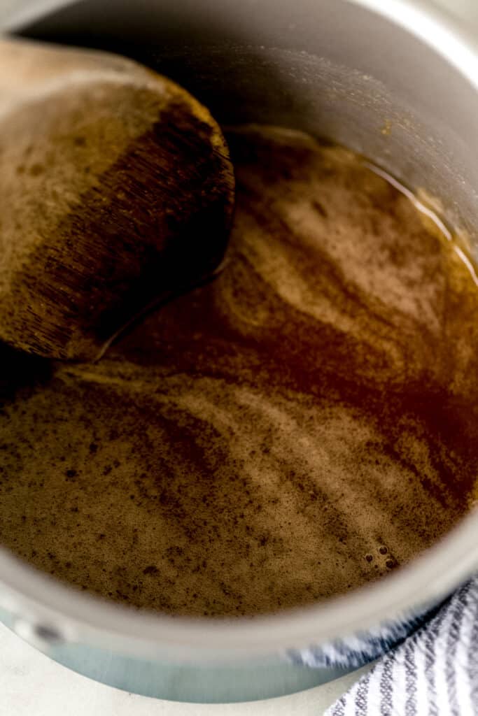 mixture for sticky buns in small saucepan with wooden spoon