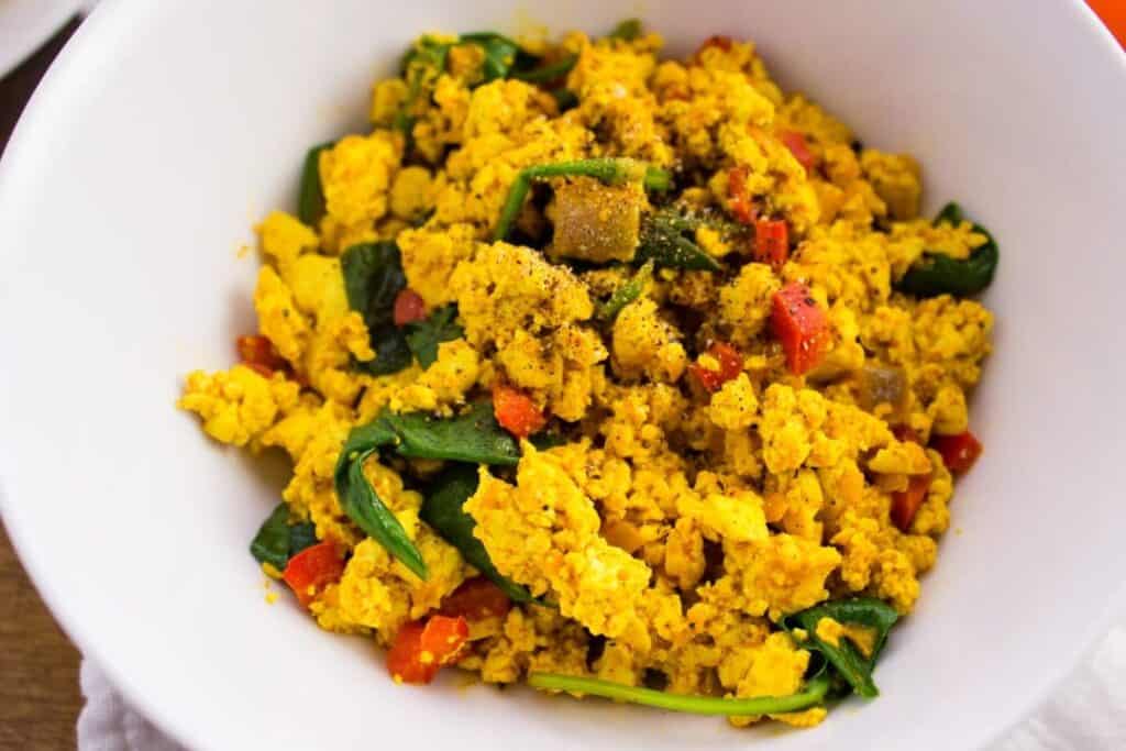 Tofu Scramble Recipe - Quick and Easy egg substitute for vegans that can be enjoyed as is or rolled into a flour tortilla for a delicious breakfast burrito. simplylakita.com #vegan #tofu