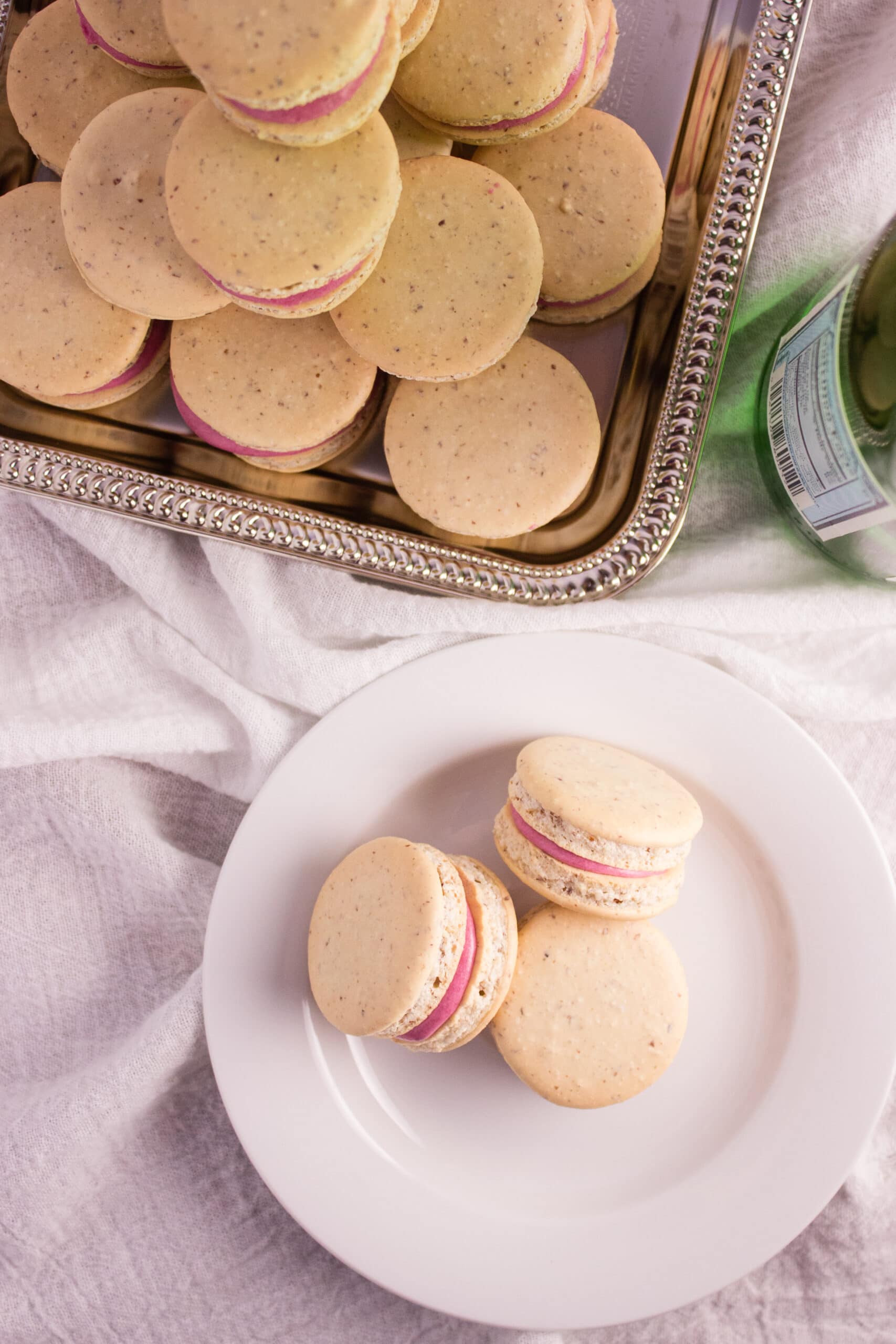 Overhead view of finished macarons on plate and tray. 