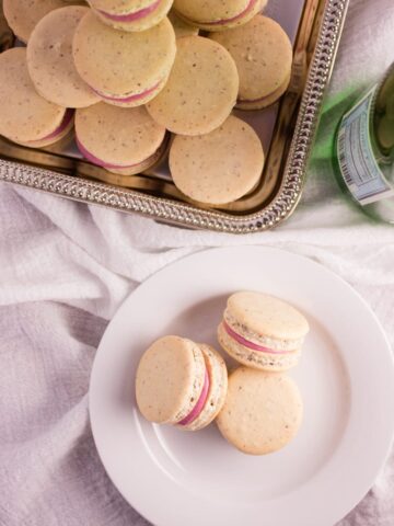 overhead photo blackberry macarons on a plate with some on silver platter