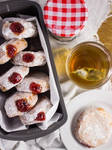 Strawberry Preserve Donuts - Deep fried cake donuts filled with strawberry preserves make the perfect treat to enjoy in bed on Mother's Day with fresh fruit and your favorite cup of coffee. simplylakita.com #donuts #strawberry
