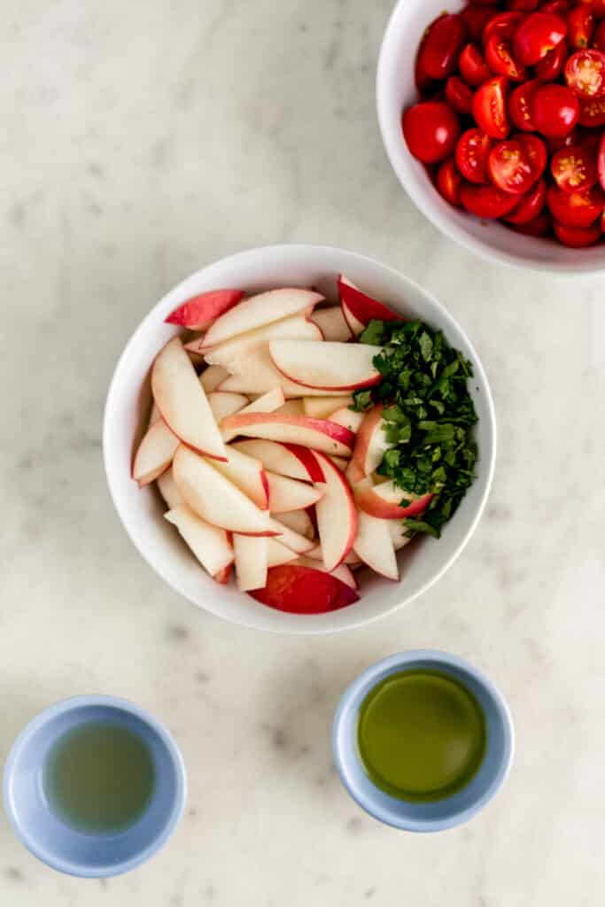 ingredients for tomato peach salad in small bowls