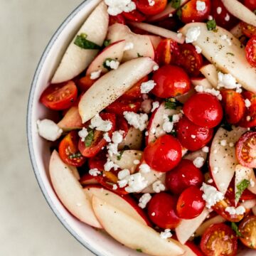 overhead view white serving bowl with tomato peach salad