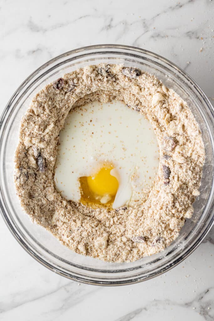 egg and buttermilk added to scone mixture in glass mixing bowl 