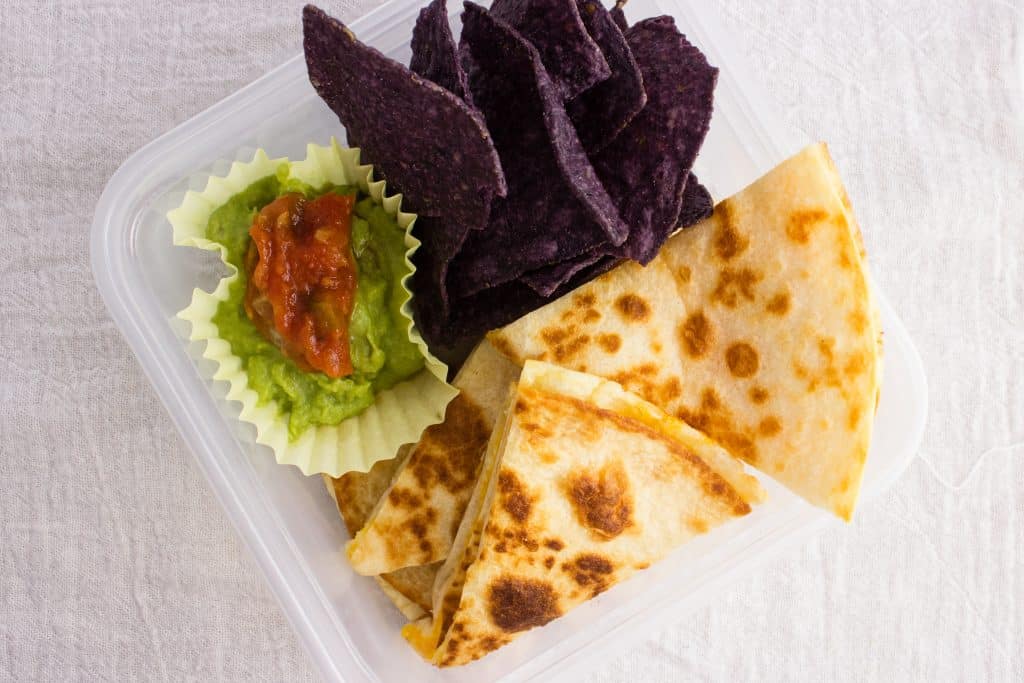 lunch in container with chip and guac