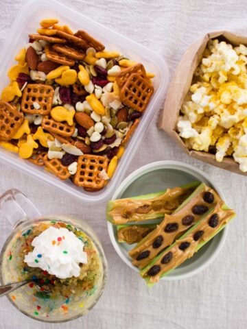 finished snacks in separate bowls and containers on cloth surface