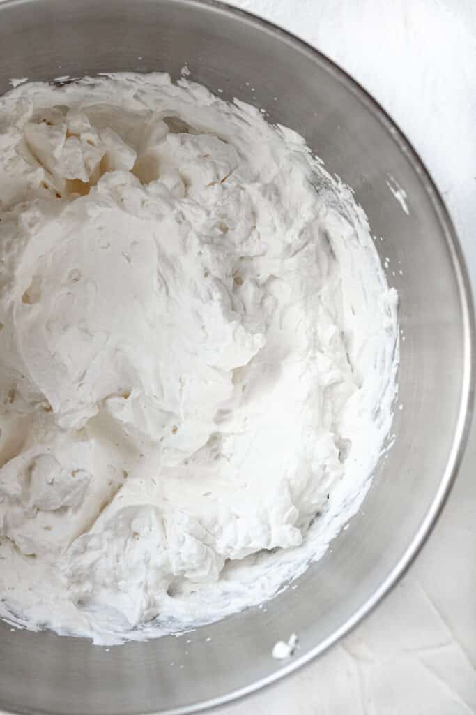 heavy whipping cream in a mixing bowl whipped into stiff peaks 