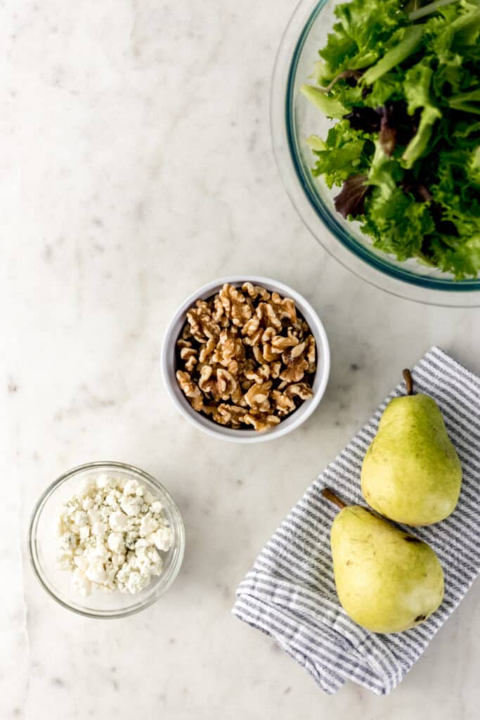 ingredients for salad in separate bowls on marble surface