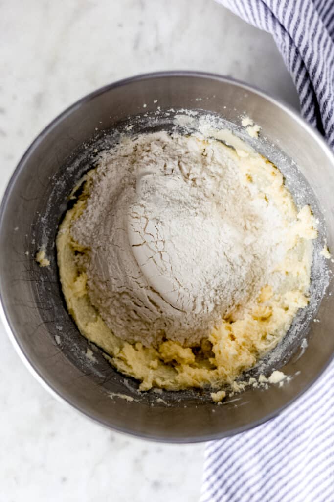 flour added into mixing bowl to make snickerdoodle cookies