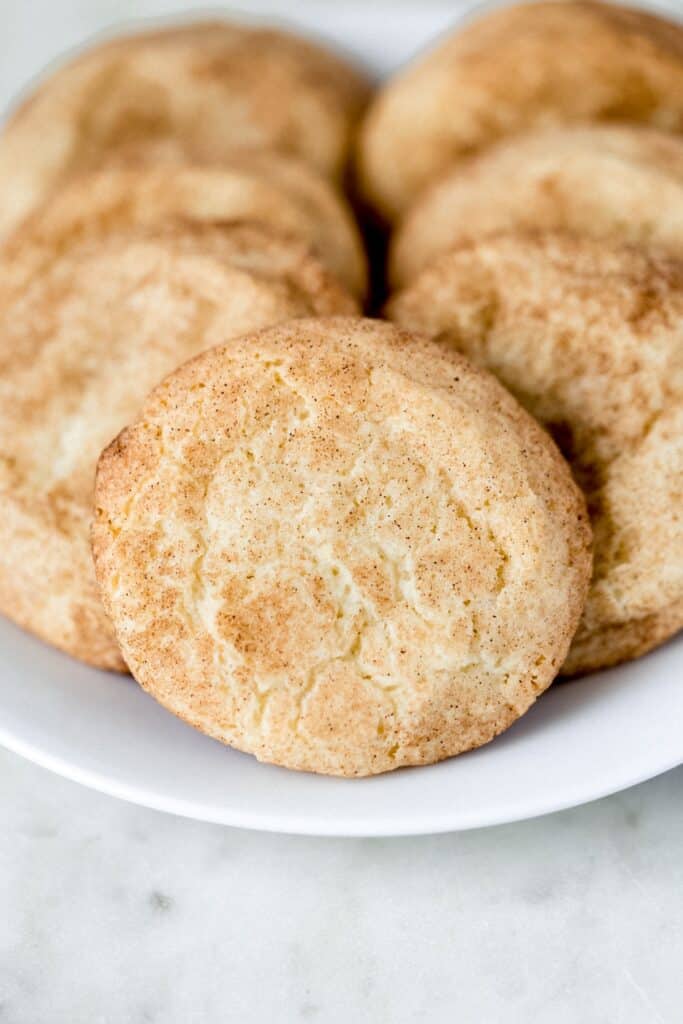 close up side view snickerdoodle cookies on a white plate