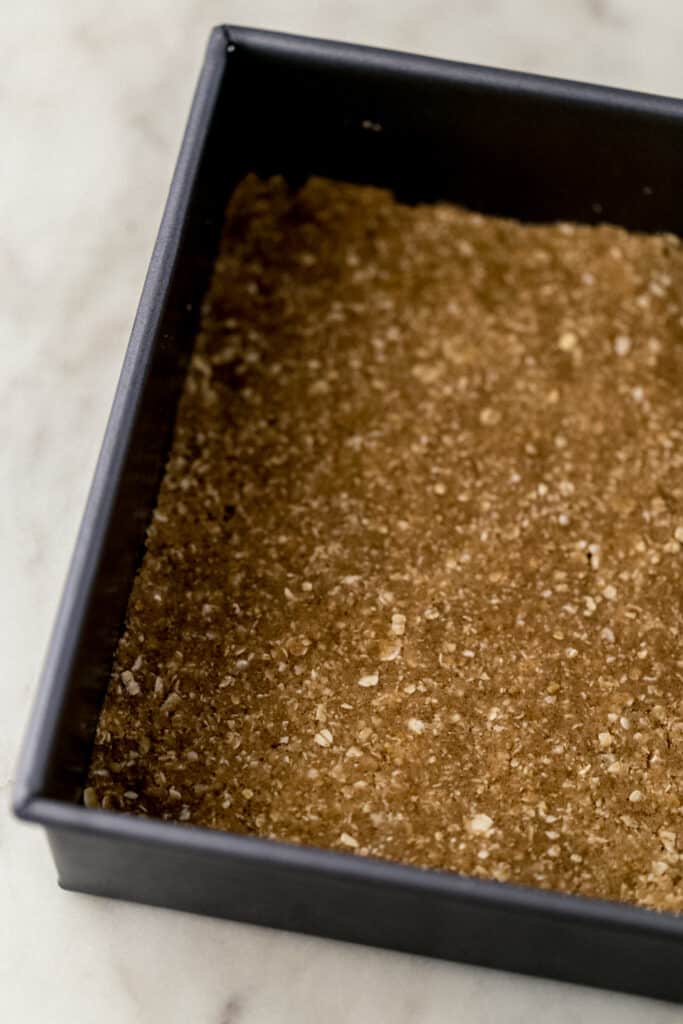 square baking pan with crust for apple bars pressed in the bottom.