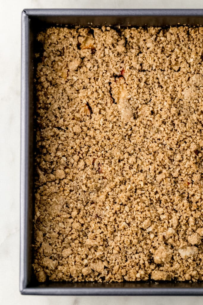 apple crumble bars in a square baking pan before baking. 