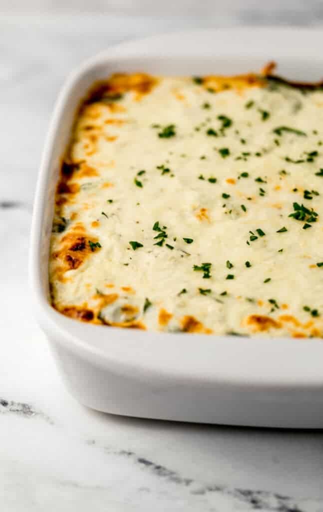 close up front view of finished lasagna in baking dish
