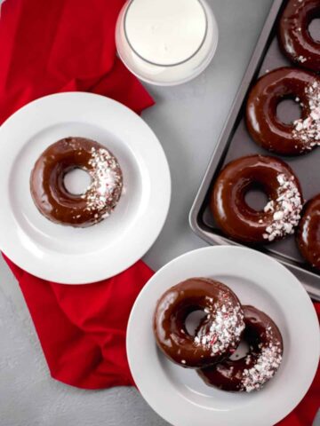 Overhead view Chocolate Peppermint Doughnuts on plates and baking sheet