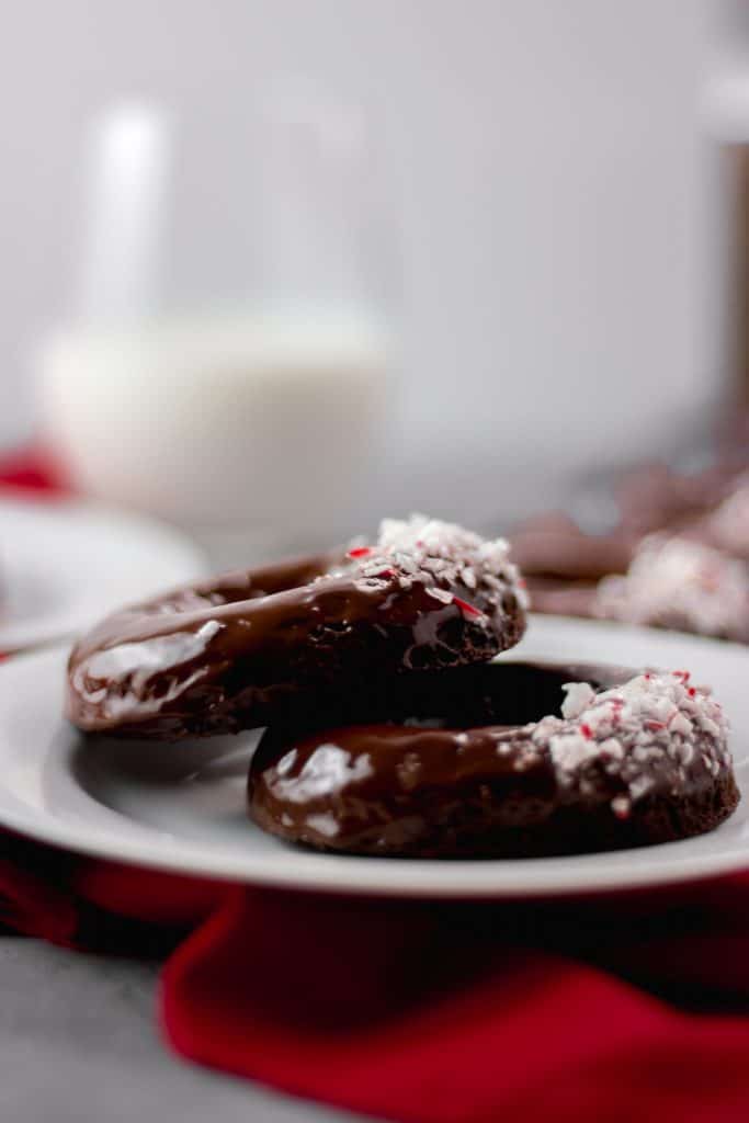Close-up side view of two Chocolate Peppermint Doughnuts on a white plate
