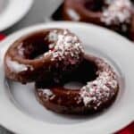 two chocolate peppermint doughnuts on plate