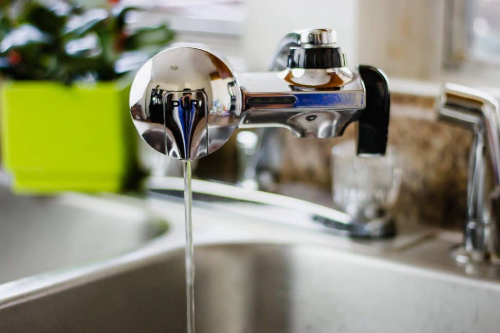 close-up side view of pur water filter with running water 