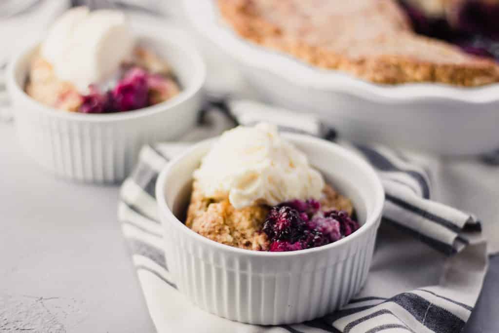 close-up side view of Blackberry Cobbler in small white bowl over cloth napkin 