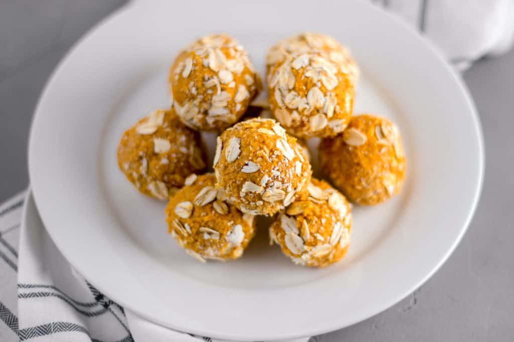 close-up side view silk no-bake energy bites for pup stacked on a white plate over a napkin