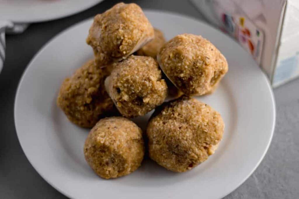 close-up side view silk no-bake energy bites stacked on a white plate 