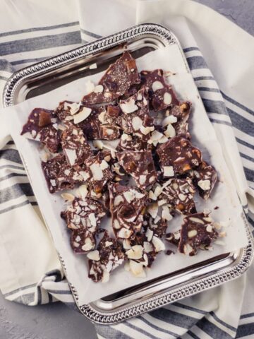 overhead view of trail mix bark on silver tray over napkin