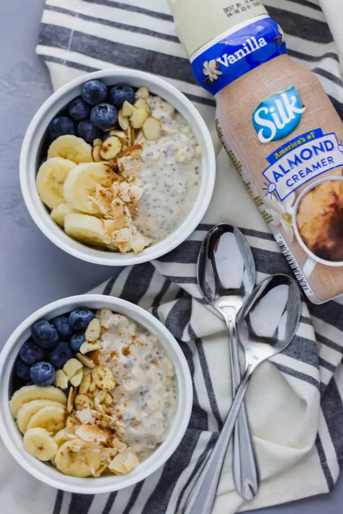 overhead view Almond Overnight Oats in two bowls with spoons 