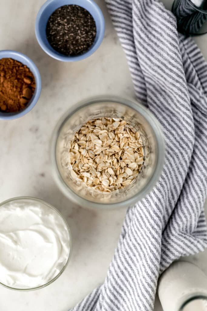 ingredients for chocolate mocha overnight oats in small containers with napkin