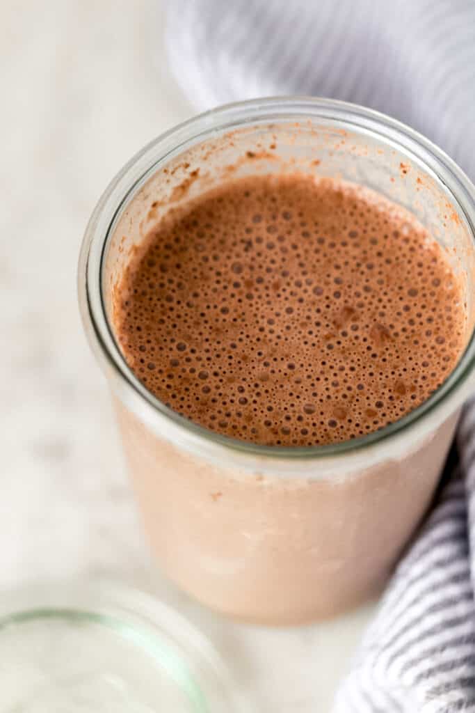 all ingredients for chocolate mocha overnight oats stirred together in glass jar