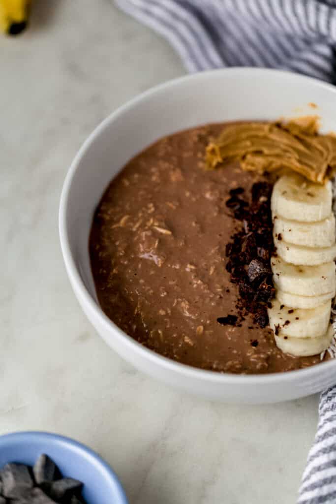 close up side view chocolate mocha overnight oats in white bowl