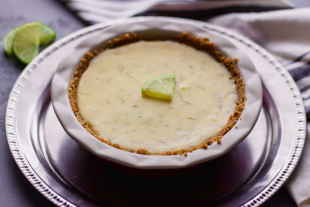 close-up side view of key lime pie for 2 on a silver platter 