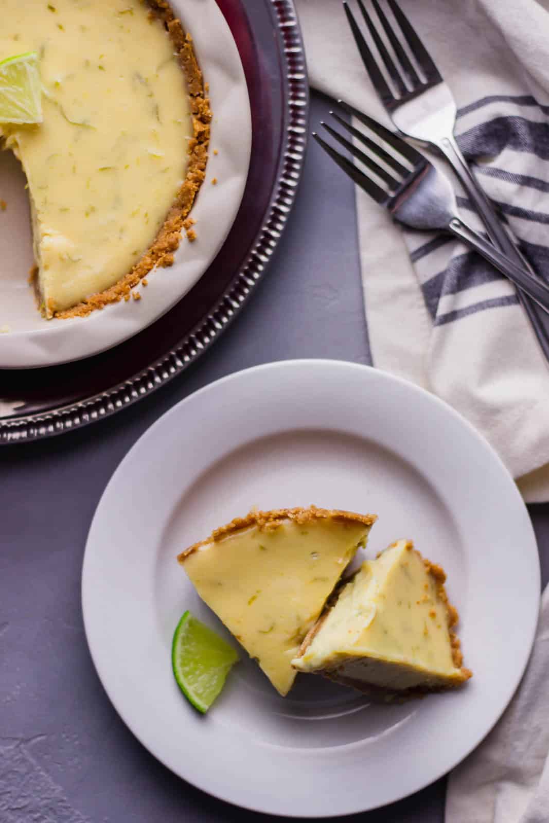 Overhead view of finished pin on plate by whole pie and forks. 