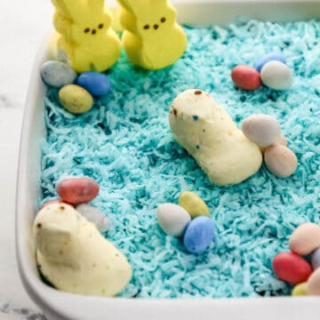Close up front view of easter dirt pudding in square white baking dish.