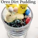Close up side view of single serving of dirt pudding in glass pudding cut on marble surface pin with text overlay.